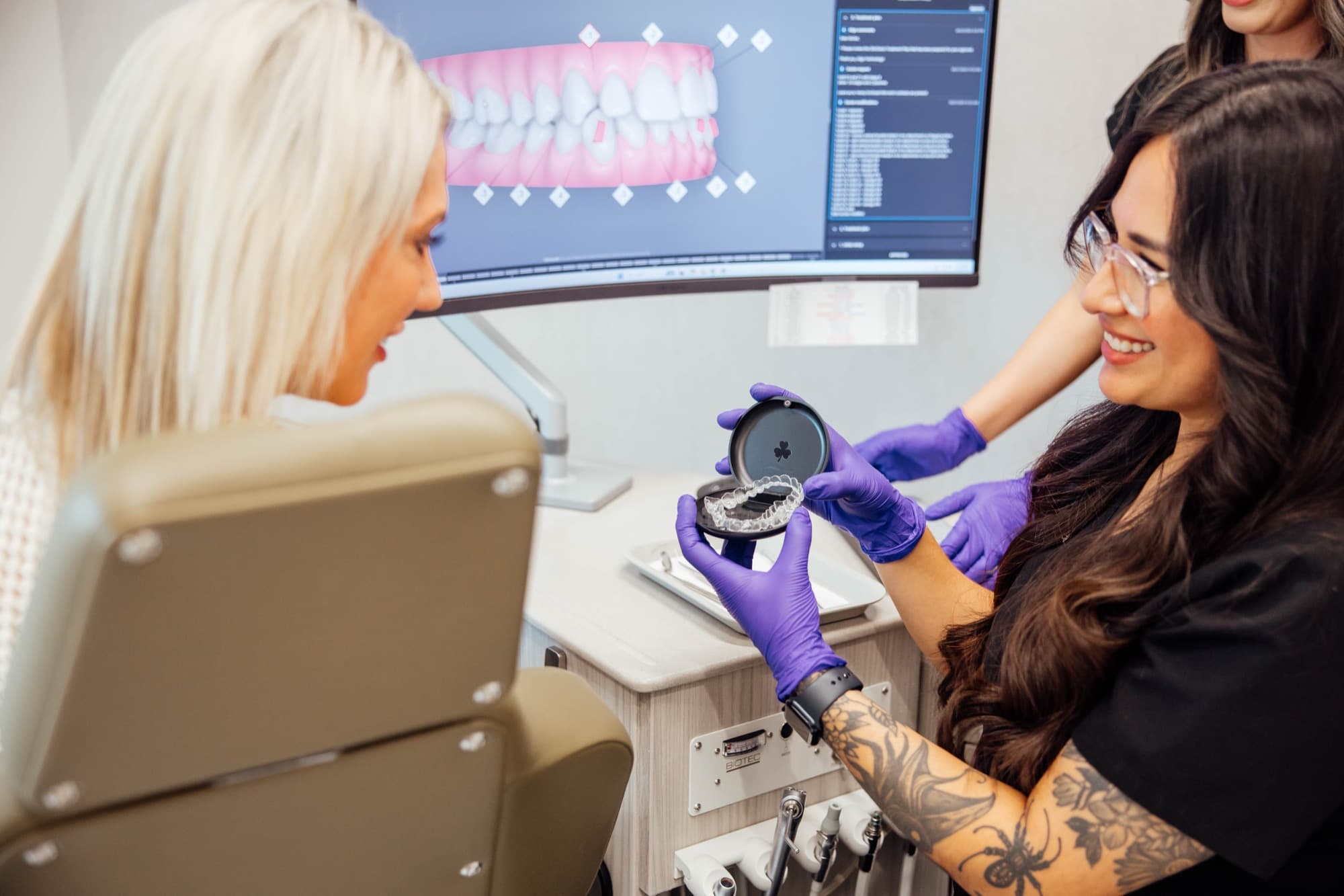 Orthodontic team showing patient their aligner