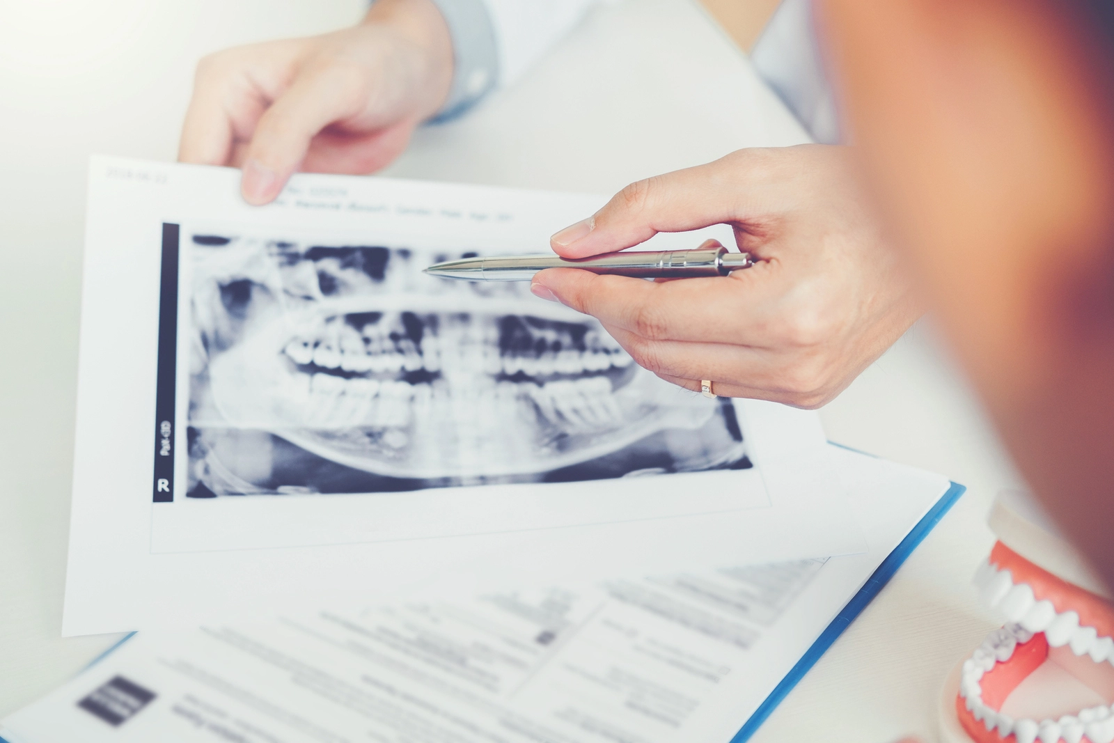 Dental School: A person reviewing x-rays with another person.