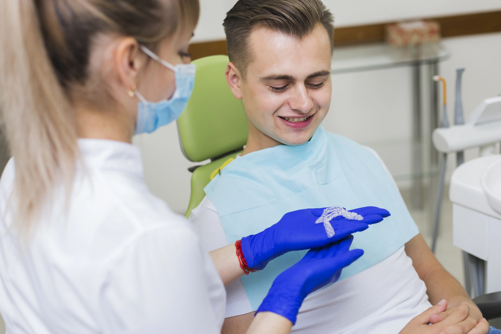 Types of treatment available: A dental professional showing clear aligners to a patient.