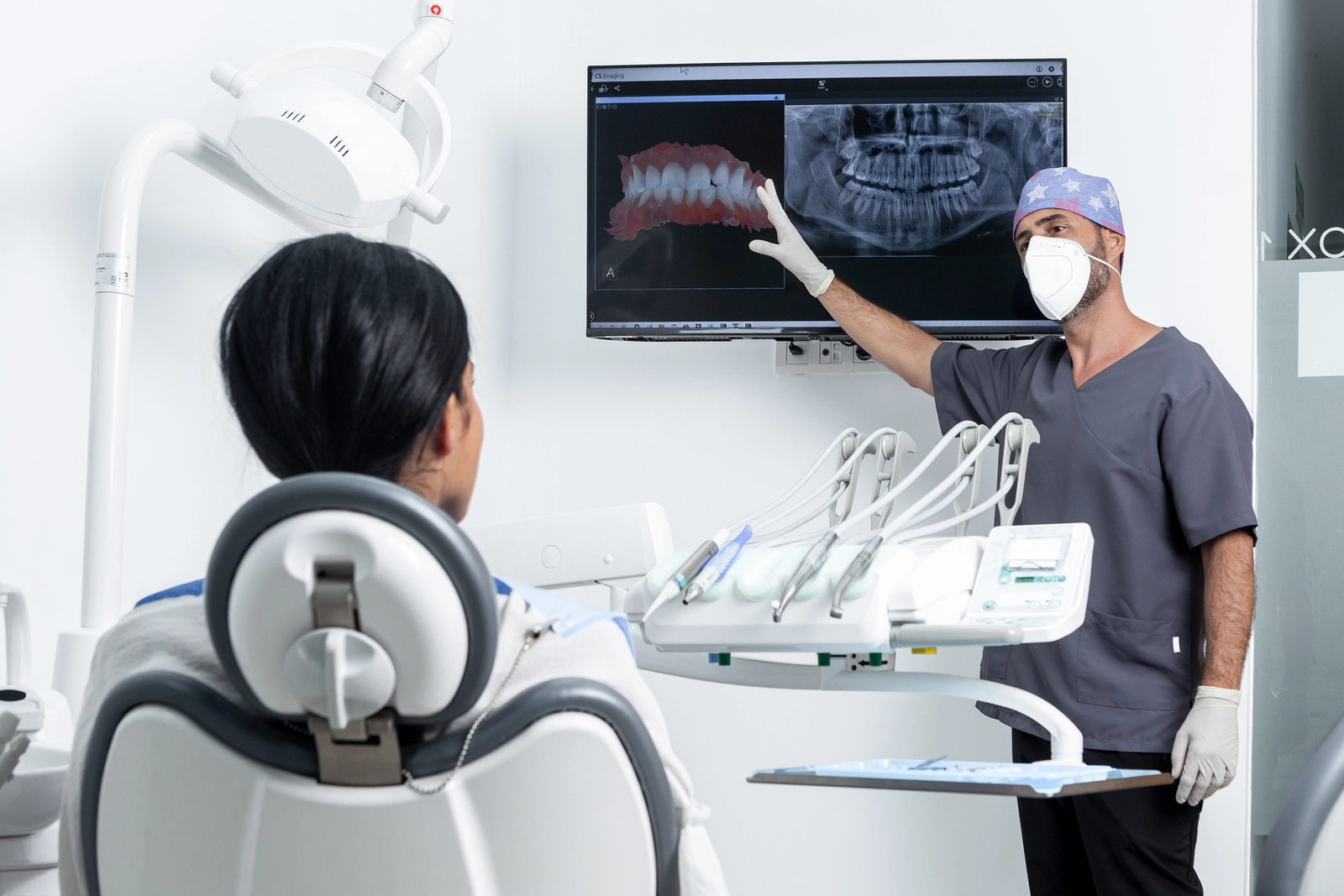 What Do Orthodontists Do? A person in a dentist chair watching an orthodontist explain x-rays