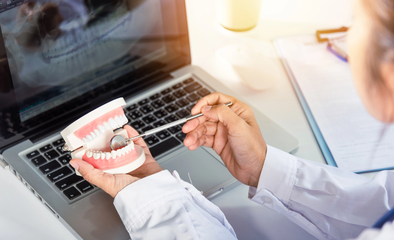 AI In Orthodontics: An orthodontist comparing X-rays on a computer to a model
